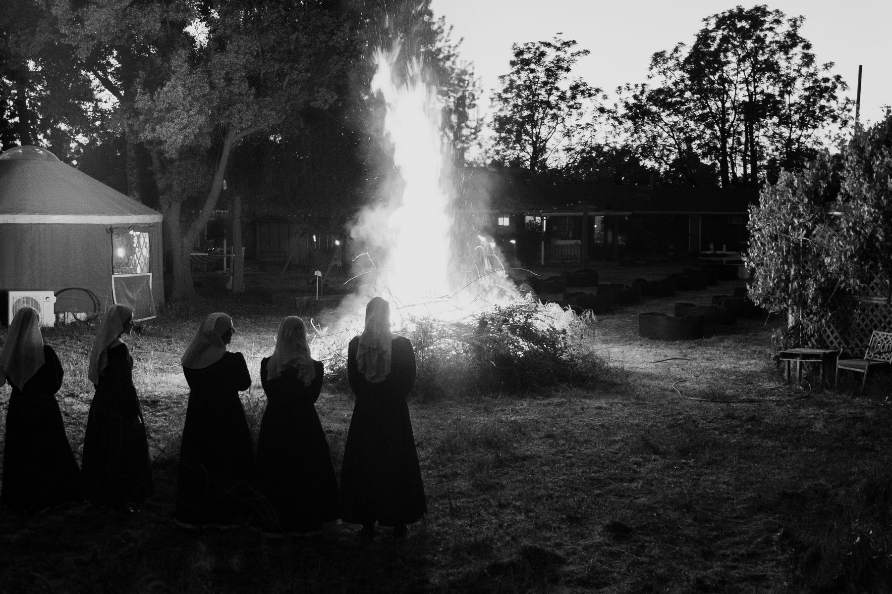 Sisters of the Valley standing in prayer before a ceremonial fire